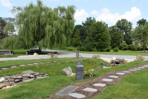 Butterfly Oasis cremation garden landscape view with stepping stones, butterfly cremation pedestal and butterfly bushes.