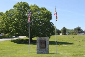 Garden of Honor monument flanked by U.S. flag and Maryland flags.
