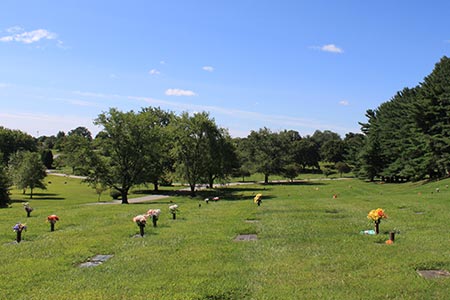 Memorial gardens with flat bronze memorial markers and flowers.